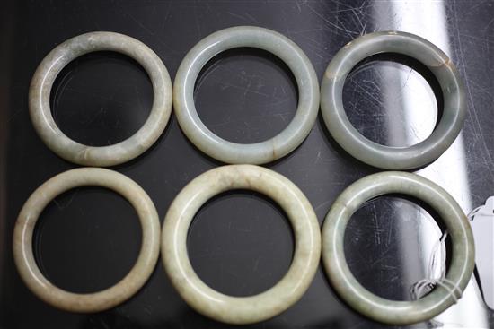 A collection of eighteen Chinese grey and green jade excavated bangles, Ming dynasty or earlier, each approx. 7.4cm diameter